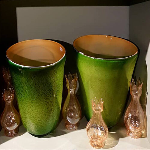 2 groene potten met kleine glazen vaasjes eromheen
